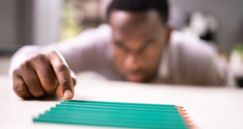man tidying pencils